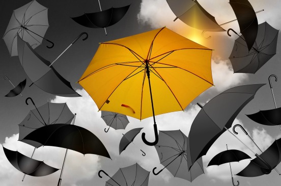 image showing black open umbrellas surrounding a central yellow one